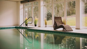 Una piscina techada, sillones reclinables de piscina