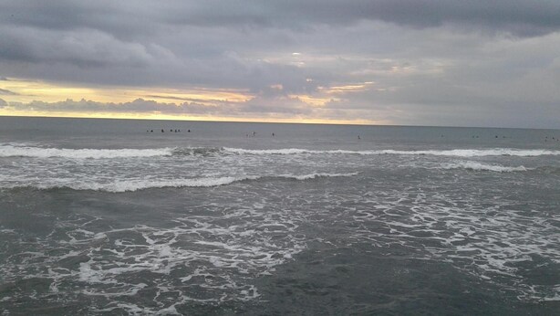 A beach with waves and a cloudy sky. - Repag Wayan Canggu Hostel (Canggu)