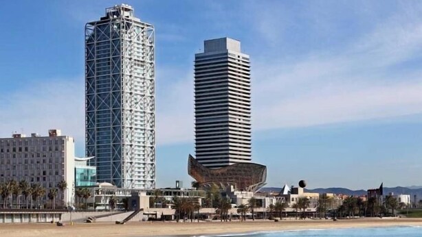 Eine Küstenstadt mit modernen Hochhäusern, einem Strand und einem klaren Himmel.