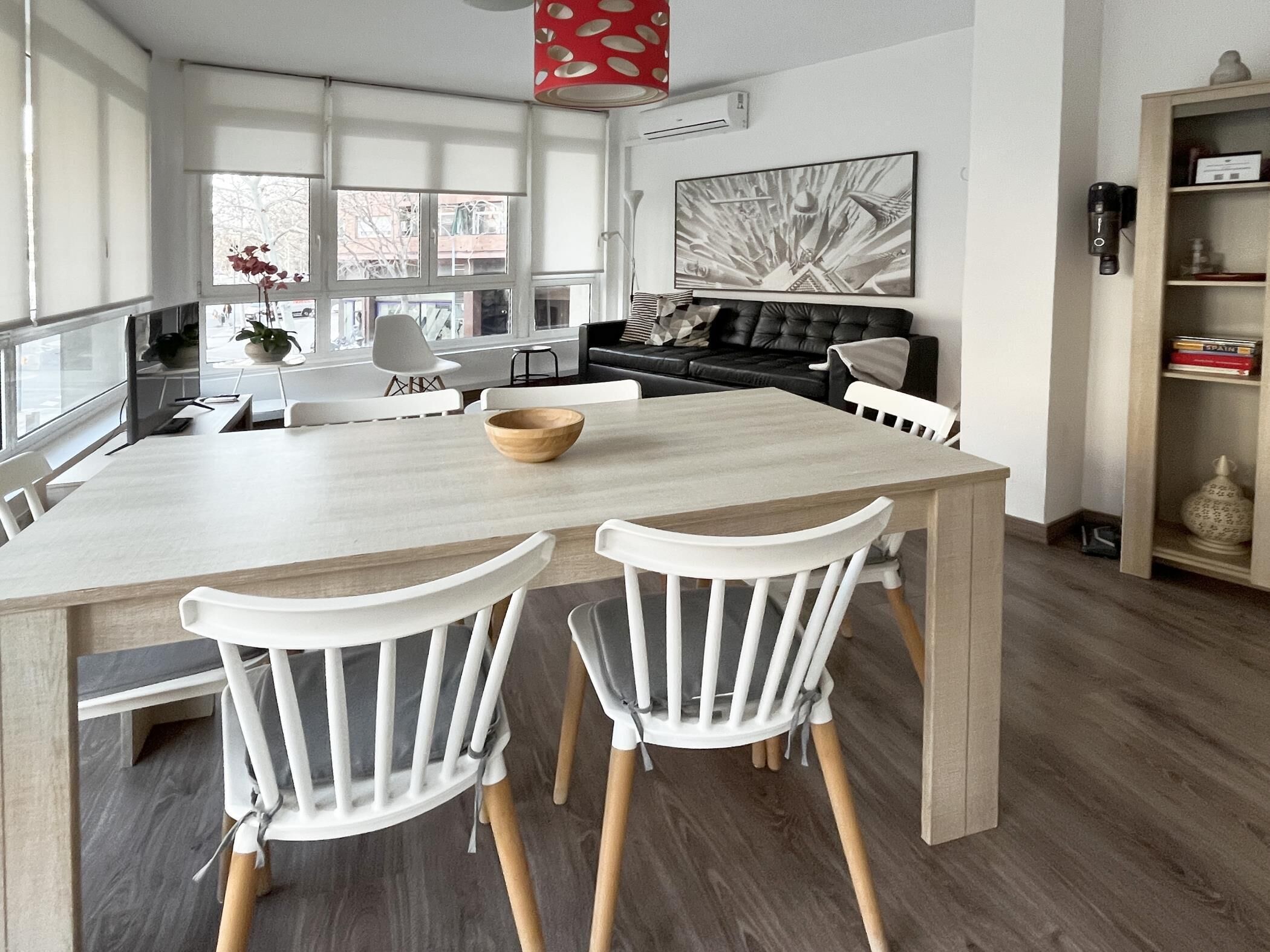 A modern kitchen with a large island, white chairs, and a dining table.