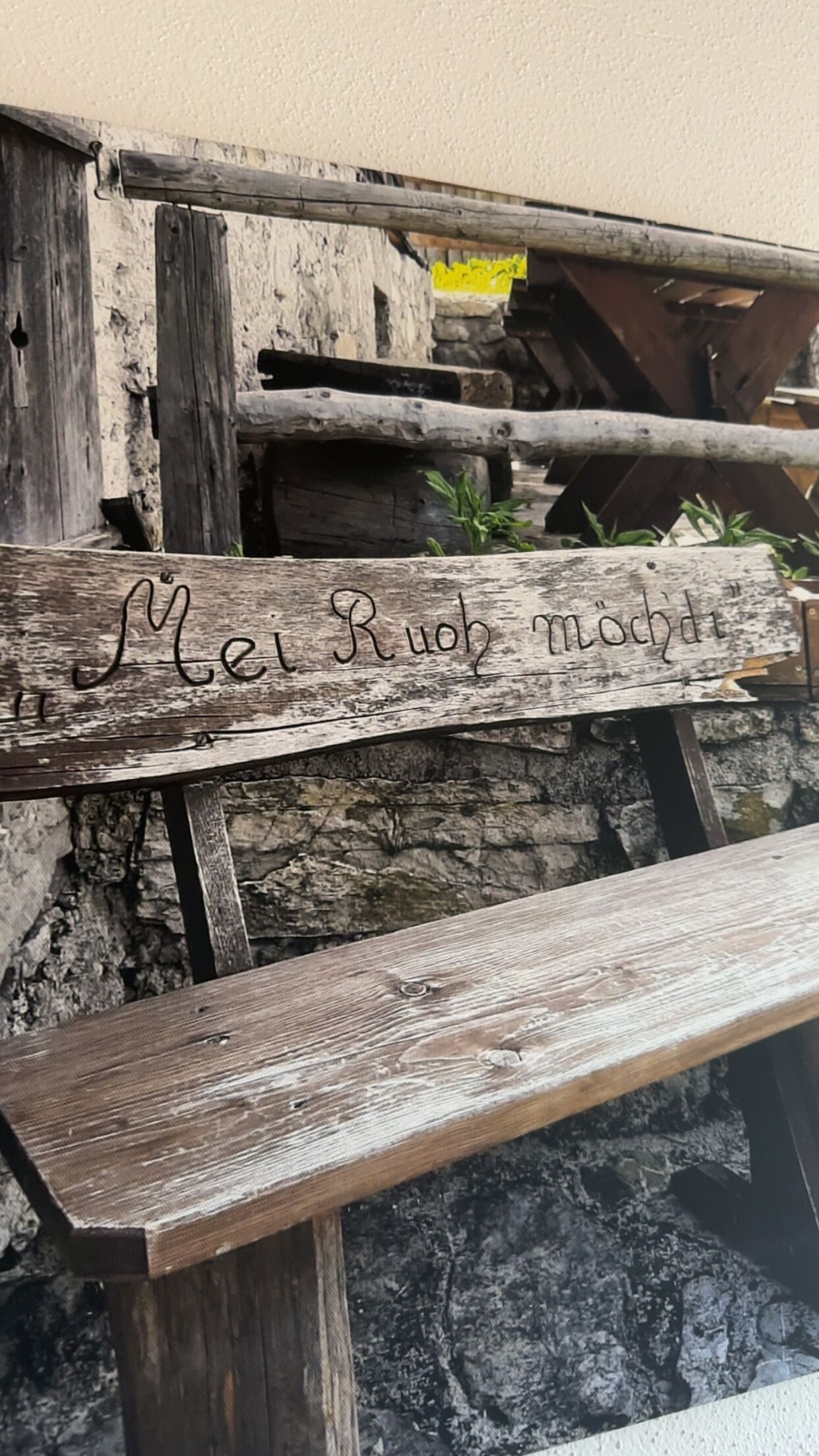 Een rustieke houten bank met een gebeeldhouwde inscriptie.