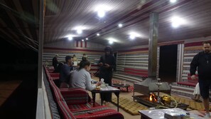 Cozy communal space with a fire pit, seating area, and dining tables.
