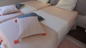 Une chambre d’hôtel avec deux lits, chacun équipé d’un oreiller et d’une couverture.