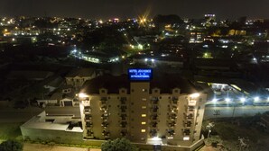 Un hôtel avec une enseigne lumineuse indiquant « HÔTEL JOUVENCE INTERNATIONAL » la nuit.