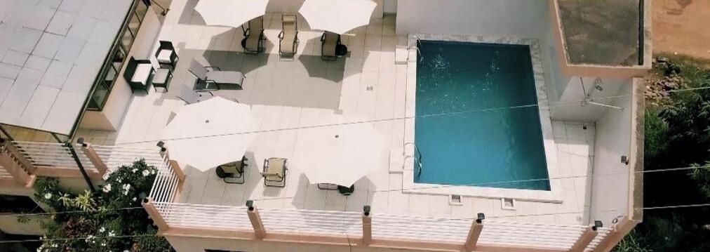 Ein Pool auf dem Dach mit Liegestühlen und einer kleinen Terrasse.