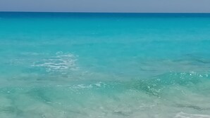 A beach with clear turquoise water and gentle waves. - Green Leaves Aqua Park Beach Resort North Coast (Al-Hammam)