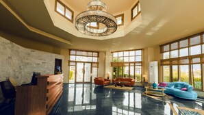 A spacious lobby with a reception desk, sofas, and a large chandelier. - Green Leaves Aqua Park Beach Resort North Coast (Al-Hammam)
