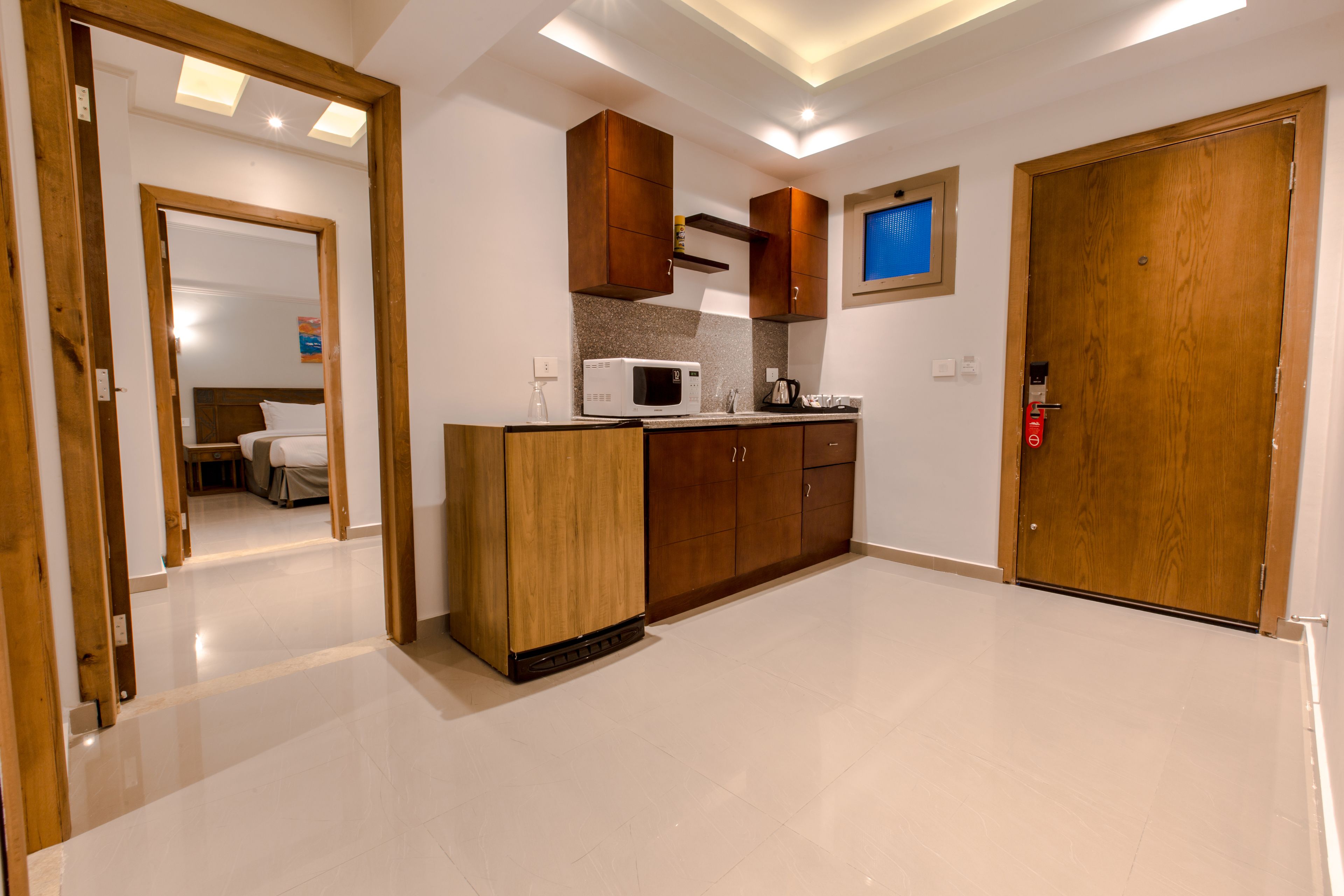 A modern kitchen with wooden cabinets, a microwave, and a coffee maker.