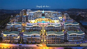 Un hotel moderno con una piscina central y varios edificios curvos.