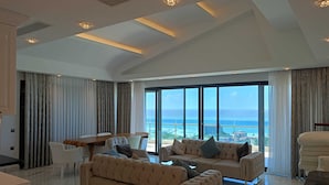 A spacious living room with a large sofa, a dining table, and a view of the ocean. - Elite Luxury Suite & Spa (Alanya)
