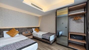 Una habitación de hotel moderna con dos camas, un armario y un espejo.