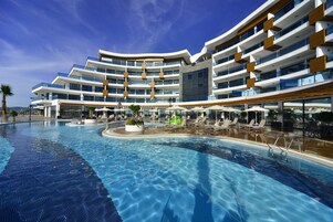 Una piscina techada, una piscina al aire libre, sombrillas