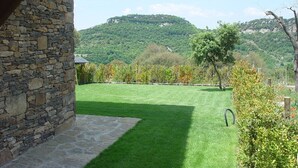 A stone building with a stone patio and a well-maintained lawn. - Rural apartment L'Alzina for 4 people (Tavertet)