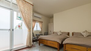 A bedroom with two beds, a desk, and a chair. - Blackfoot Homestay (Taitung)