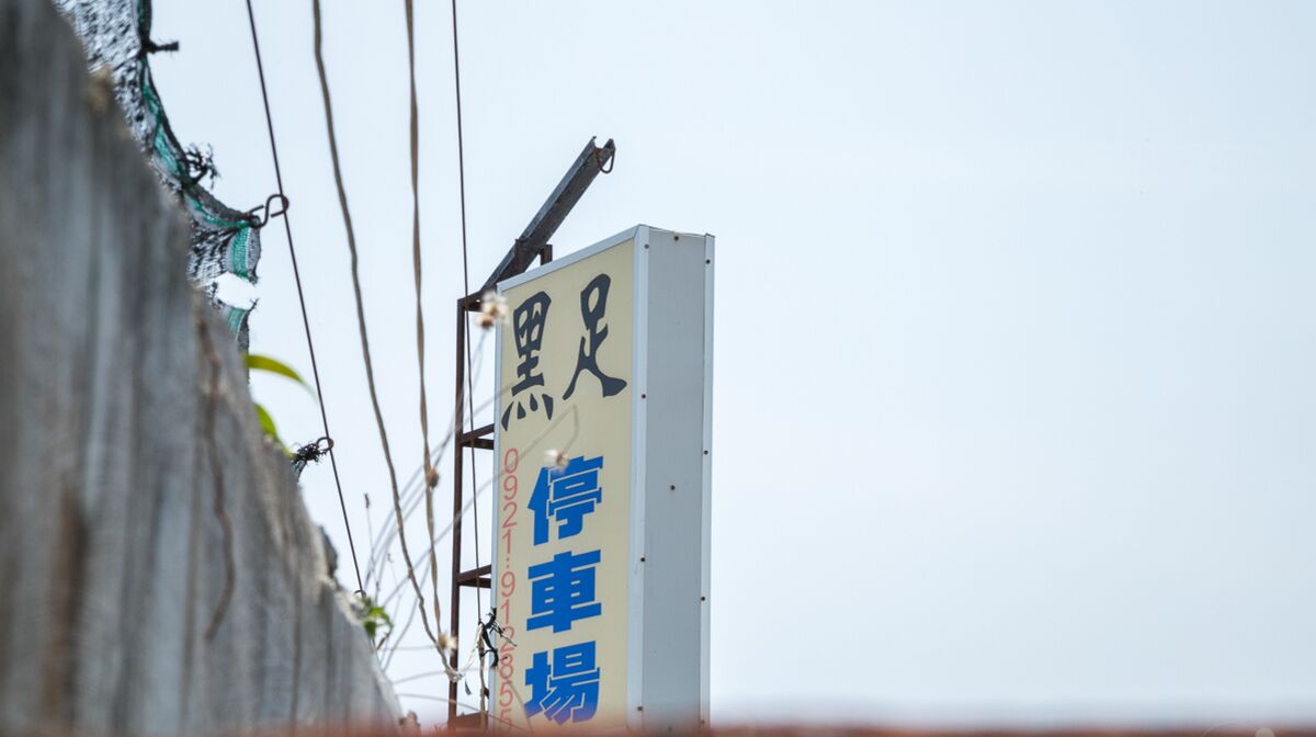 A sign with Chinese characters and a crane, indicating a construction or repair site.