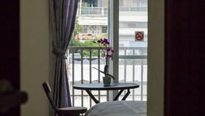 A balcony with a small table, a chair, and a potted plant with purple flowers. - Blackfoot Homestay (Taitung)