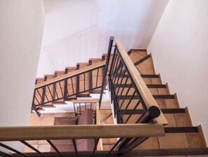 A spiral staircase with wooden steps and black metal railings. - THE HOUSE OF LA VEGA (Villaspesa)