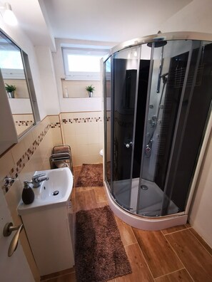 Regadera, secadora de cabello, pantuflas, toallas 