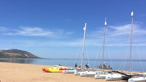 A beach with several sailboats docked and a lifeguard tower in the background. - Spacious Villa, Large Private Pool, Outdoor Jacuzzi, Attractive Gardens, 10 min walk to the Beach! (Latchi)