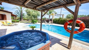 A pool area with a hot tub, lounge chairs, and a lifebuoy. - Spacious Villa, Large Private Pool, Outdoor Jacuzzi, Attractive Gardens, 10 min walk to the Beach! (Latchi)