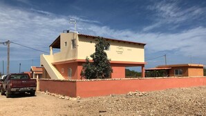 A two-story building with a flat roof, a small attached structure, and a paved driveway. - Bahari 1st floor mountain, sea and riviera view (3 p) (Morro)