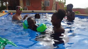 A swimming pool with people enjoying the water, a house in the background, and a clear sky. - Bahari 1st floor mountain, sea and riviera view (3 p) (Morro)