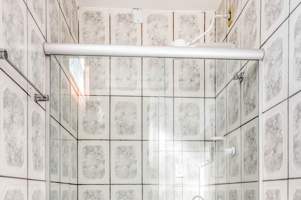Un baño con cabina de ducha, inodoro y lavamanos.