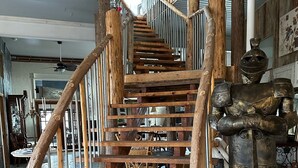 A wooden staircase with metal railings and a decorative metal sculpture at the bottom. - The Purple Martin Inn (Rogers City)