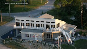 A two-story building with a balcony and a staircase leading to the upper level. - The Purple Martin Inn (Rogers City)