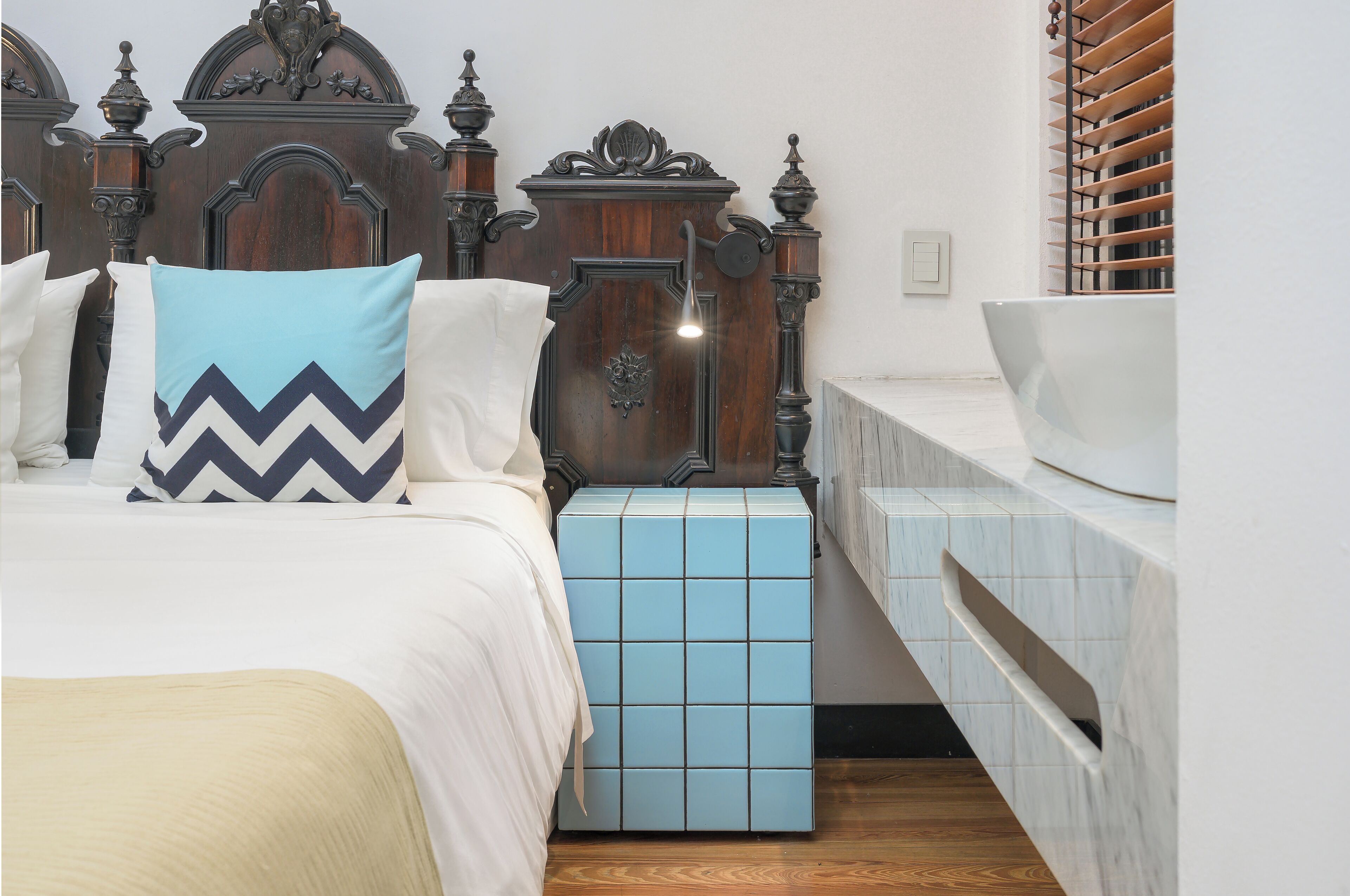 Un dormitorio con una cama grande, una mesita de noche, un aparador y un cabecero de madera.