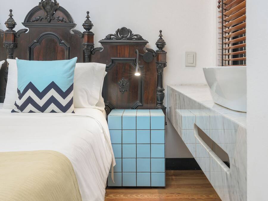 Un dormitorio con una cama grande, una mesita de noche, un aparador y un cabecero de madera.