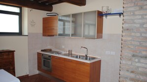 A kitchen with wooden cabinets, a double sink, and a tiled backsplash.