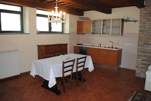 A kitchen with a dining table, chairs, and a chandelier. - Nice loft near the city center. (Firenze)