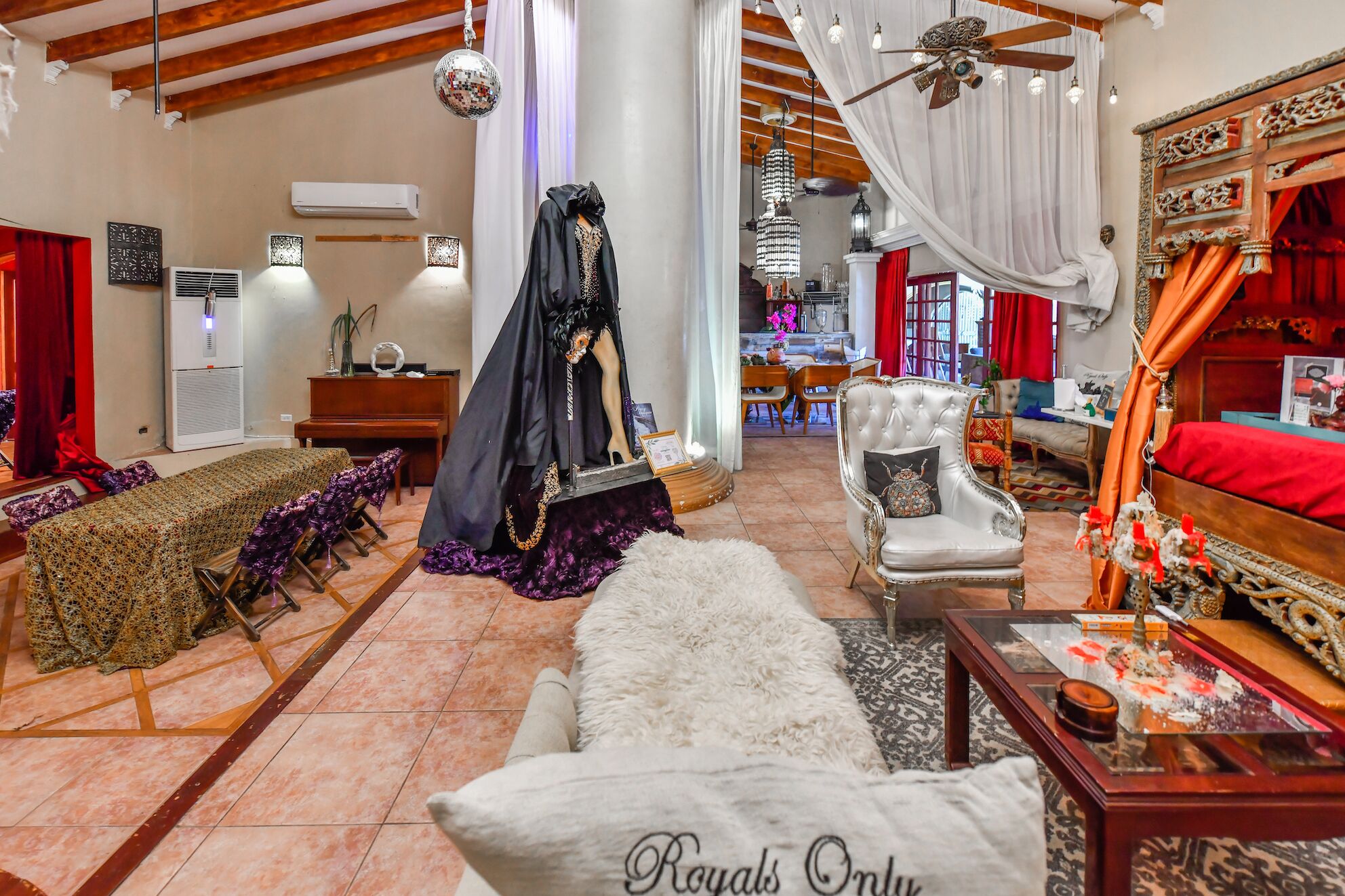 A luxurious living room with a grand piano, a white sofa, and a decorative chandelier.