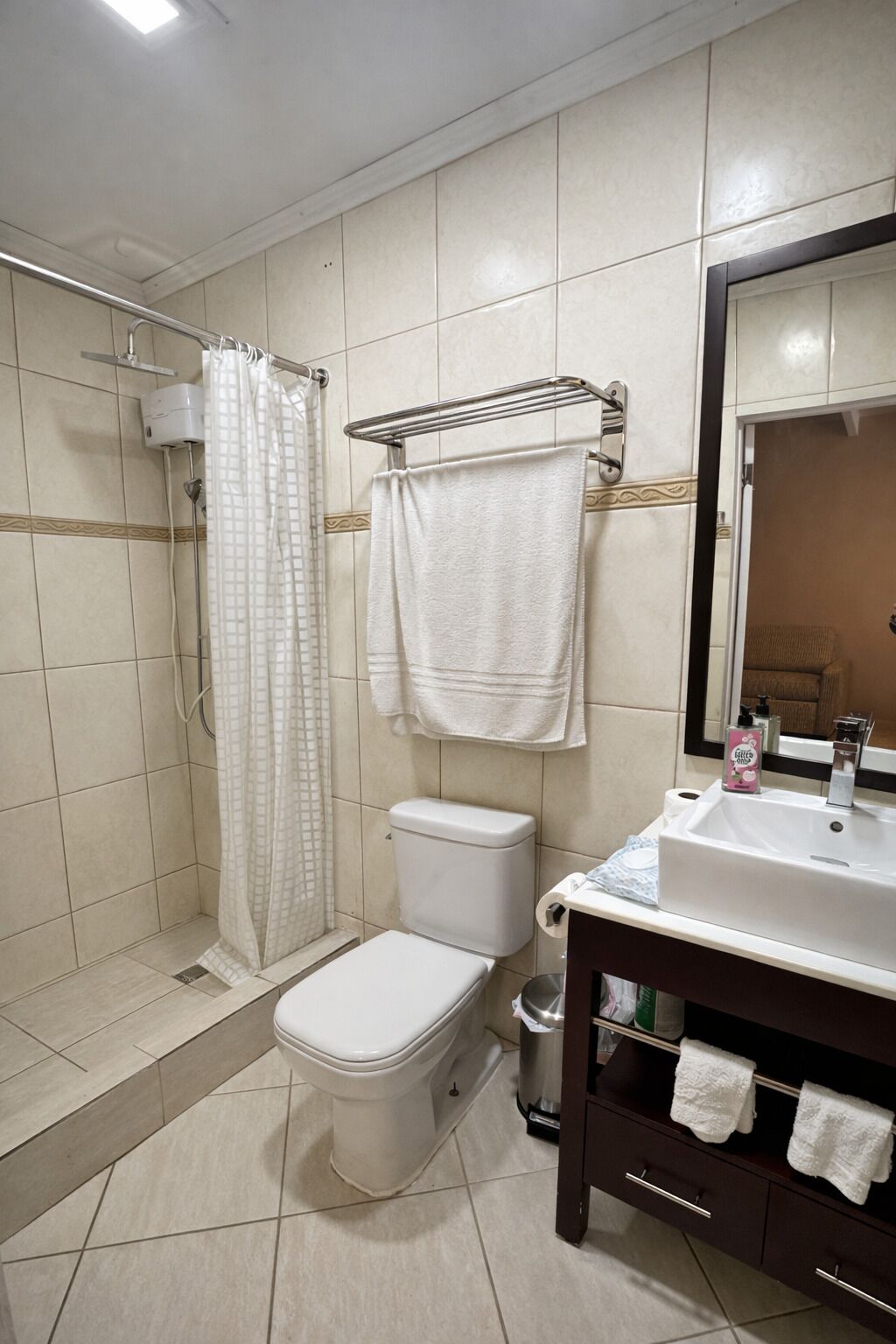 A bathroom with a shower, toilet, and sink.