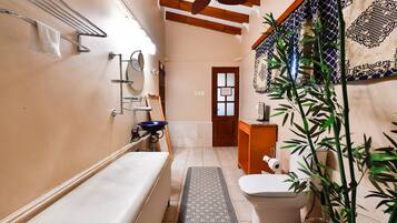 Un baño pequeño con bañera, inodoro y lavamanos.