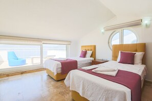 A hotel room with two beds, a large window, and a balcony.