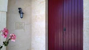 A red door with a metal handle and a small metal plate with the text "Ta Cikku" on a beige wall. - Ta Cikku, a luxury 5 bedroom with villa  with pool for family, friends and fun.  (Gharb)