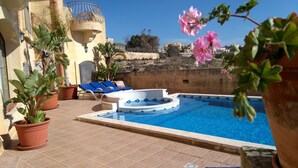 A swimming pool with a hot tub, surrounded by potted plants and blue lounge chairs. - Ta Cikku, a luxury 5 bedroom with villa  with pool for family, friends and fun.  (Gharb)