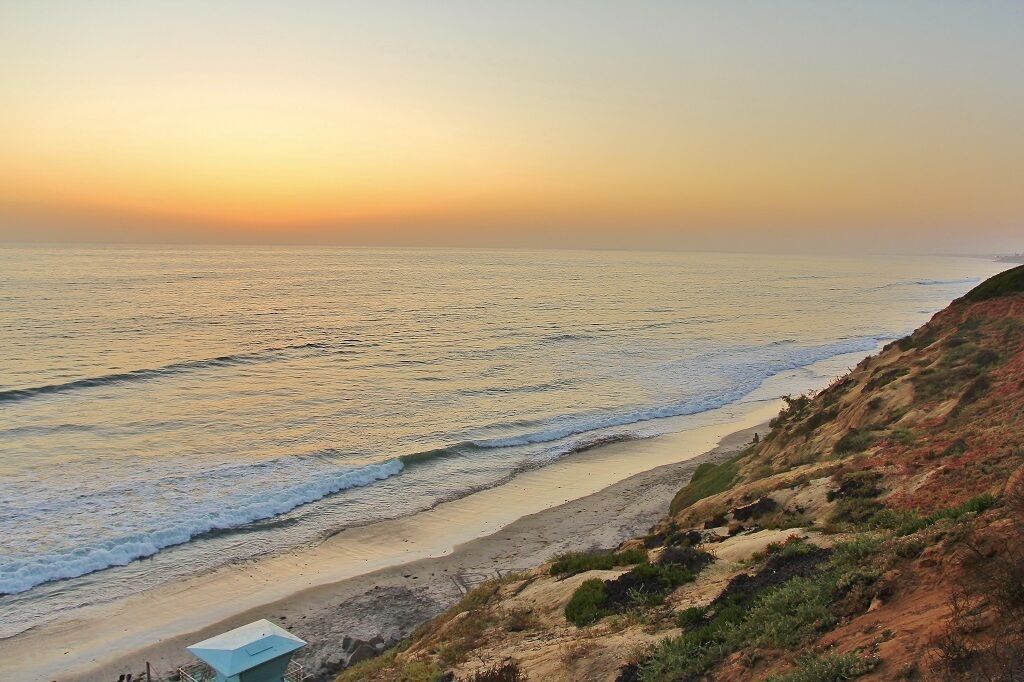 A beach with a clear view of the ocean and a sandy shore.