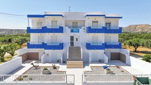 Un bâtiment moderne doté d’un escalier central, de nombreux balcons et d’une enseigne indiquant « Pitas Studios ».