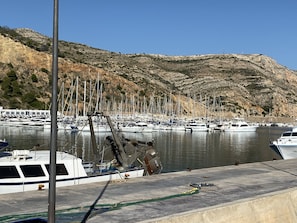 Boats docked at a marina surrounded by rocky hills.