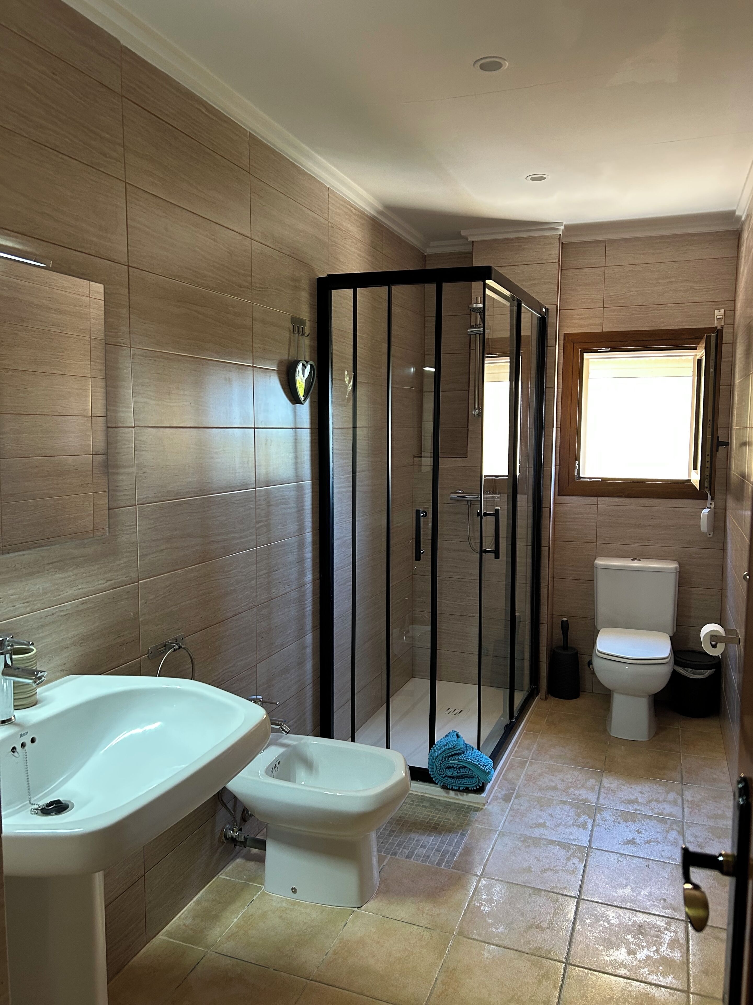 A bathroom with a shower enclosure, a toilet, and a bidet.