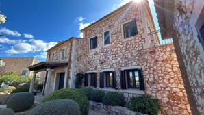 A stone building with multiple windows and a balcony. - Luxury villa with panoramic sea views for 12 people, large pool, BBQ house  (Cala Murada)