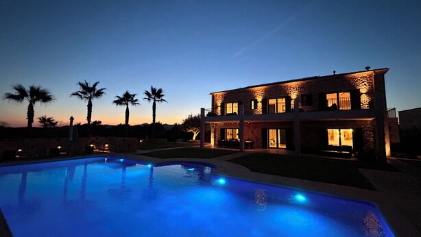 A two-story house with a swimming pool at dusk. - Luxury villa with panoramic sea views for 12 people, large pool, BBQ house  (Cala Murada)