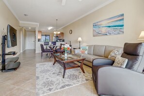 A modern living room with a sofa, coffee table, and dining area.