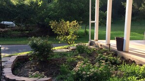 A landscaped garden with a brick border, a small tree, and a potted plant. - LEEDS A GREAT ESCAPE (Leeds)