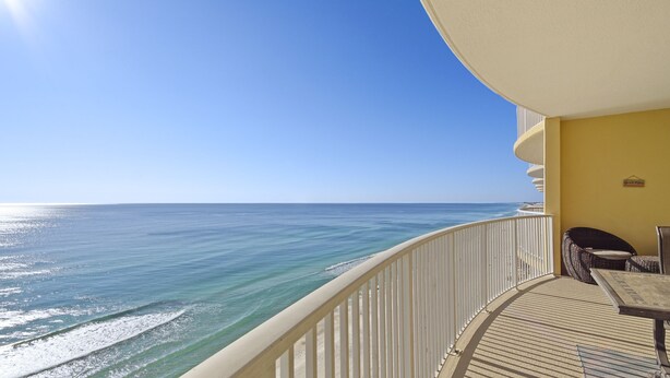 A balcony with a view of the ocean, a chair, and a table. - Emerald Isle 1607 - Front row beach chair service included! Affordable rates! (Panama City Beach)