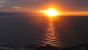 Ein Sonnenuntergang über einem Gewässer mit klarem Horizont.
