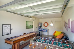 Ein Zimmer mit einem Kicker, einem Billardtisch und einem Wandposter mit einer Raumfähre.